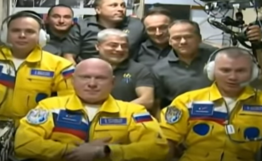 Drei Kosmonauten in gelb-blauen Anzügen bei der ISS angekommen